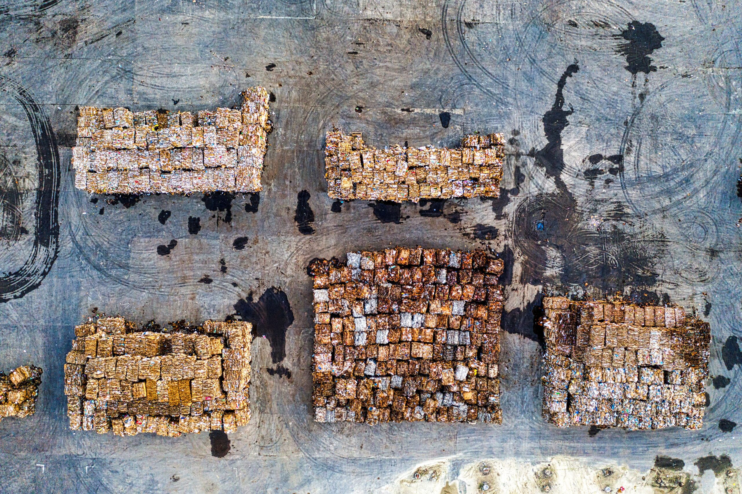 Aerial shot of organized recyclable waste or material stacks in Serang, Indonesia, highlighting waste management efforts.